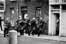 Don McCullin / British Soldiers dressed like Samurais charge stone-throwing youths, / 1970