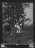 Arnold Genthe / Bruce, Mrs., and Miss Hedman, seated outdoors on a fence / 1919 May 30