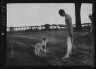 Arnold Genthe / Cosgrave, Mr., with dog, outdoors / not before 1917