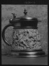 Arnold Genthe / Beer stein decorated with relief carvings of mythological figures / 1923