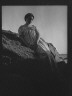 Arnold Genthe / Wilson, Helen, Mrs., seated on rocks at the beach / between 1906 and 1928