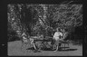 Arnold Genthe / Benson, Mary, Mrs., and two identified women seated outdoors at a table / between 1933 and 1942