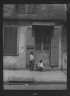 Arnold Genthe / Two children outside a door with shutters in the French Quarter, New Orleans / between 1920 and 1926