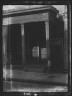 Arnold Genthe / Boy standing on a sidewalk by a doorway, New Orleans or Charleston, South Carolina / between 1920 and 1926