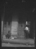 Arnold Genthe / Woman sitting on steps and man standing in a doorway, New Orleans / between 1920 and 1926