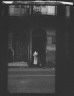 Arnold Genthe / View from across street of a woman cleaning the sidewalk, New Orleans / between 1920 and 1926