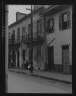 Arnold Genthe / View from across street of four people talking in the French Quarter, New Orleans / between 1920 and 1926