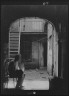 Arnold Genthe / Man seated in archway leading to a courtyard, New Orleans / between 1920 and 1926