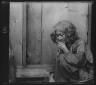 Arnold Genthe / Ainu woman seated by the door of a wooden hut / 1908