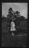 Arnold Genthe / Skidmore, Nina, standing in front of a large sunflower / 1913