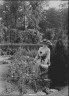 Arnold Genthe / Truesdale, W., Mrs., standing in a garden / 1915 July 6