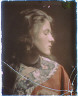 Arnold Genthe / Head and shoulders of a woman with brown hair wearing a red robe or kimono decorated with birds and flowers / between 1906 and 1942