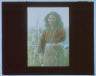 Arnold Genthe / Ainu woman standing outside in front of a pole fence / between 1908 and 1942; from a negative taken in 1908