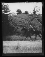 Unidentified man riding a horse