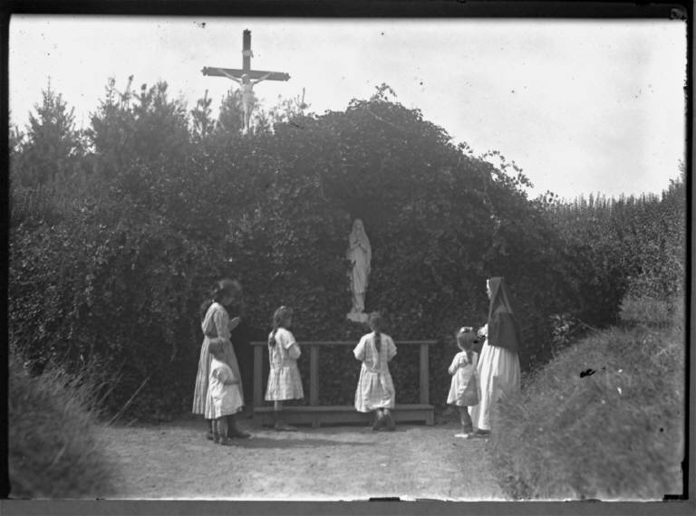 Children Pray By Statue